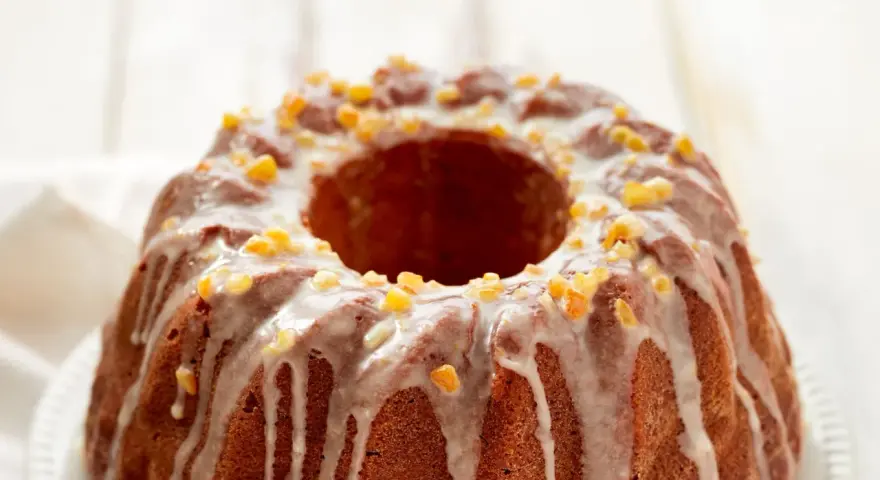 Dolce ciambellone glassato con scorzette d'arancia candita, perfetto per il tuo murzynek przepis.
