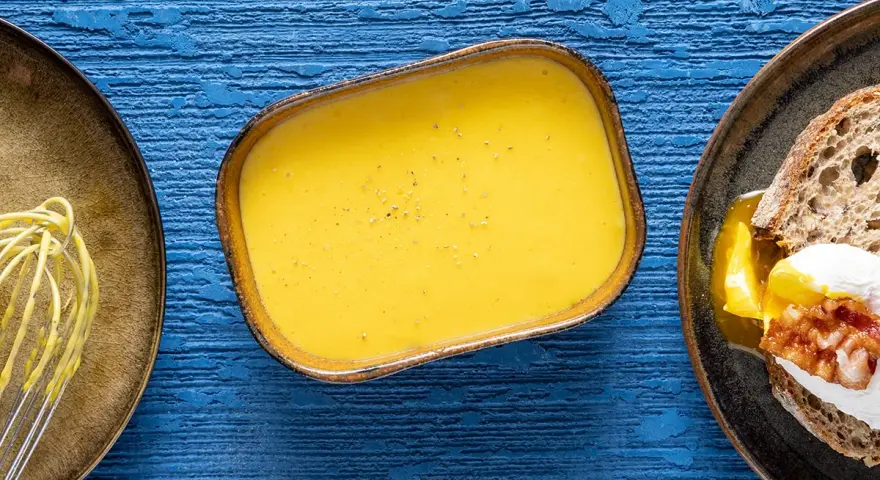 Salsa olandese, perfetta per la tua sfoglia olandese ricetta. Accanto, un uovo in camicia su pane tostato.