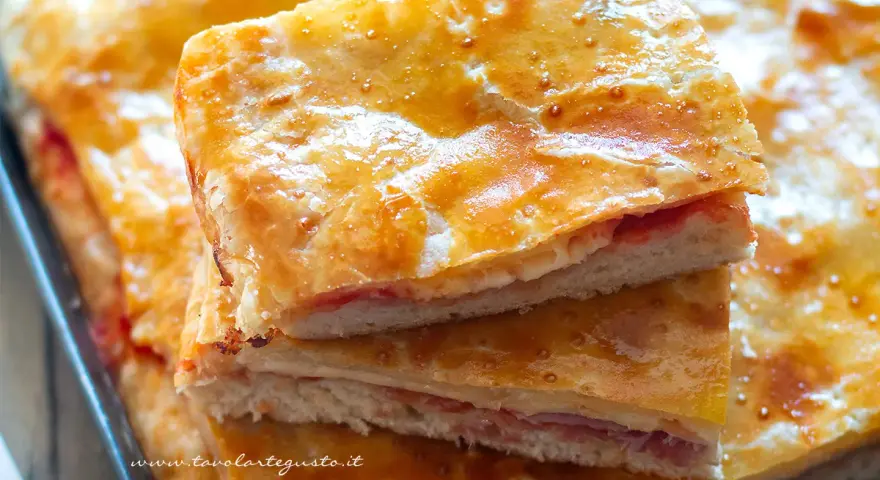 Fette di torta salata con pasta sfoglia dorata e ripieno di prosciutto e formaggio. Ecco come conservare la pasta sfoglia cotta per gustarla al meglio.