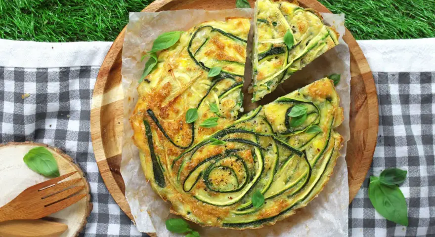 Frittata con verdure miste, un piatto gustoso e colorato, perfetto per un picnic sull'erba.