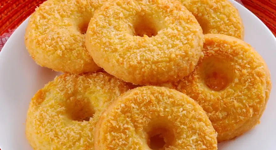 Oponki serowe, dorate con cocco grattugiato, invitano a un dolce assaggio.