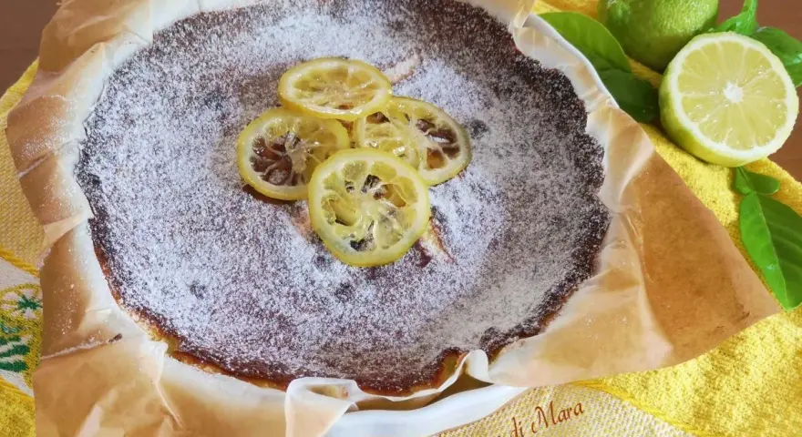 Torta al limone cosparsa di zucchero a velo, decorata con fette di limone caramellate. Freschezza e dolcezza in un morso.
