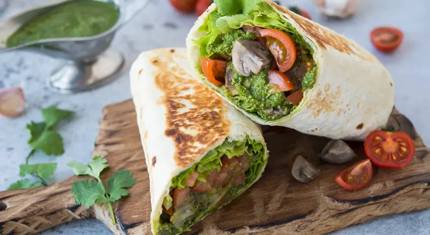 Piadina con pesto, pomodoro e lattuga, un pasto fresco e saporito.