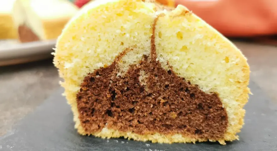 Fetta di ciambella bicolore, chiara e al cacao, soffice e gustosa, perfetta come ciambella per celiaci.