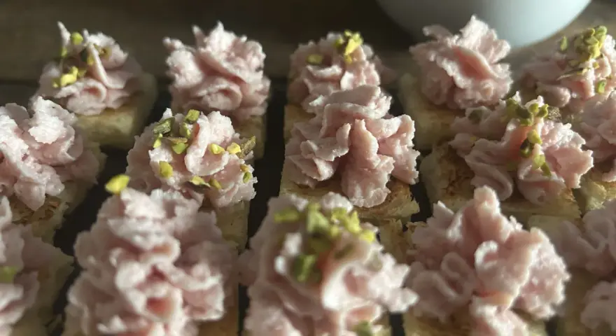 Deliziosi crostini con mortadella, stracciatella e pistacchi, pronti per un aperitivo gustoso.