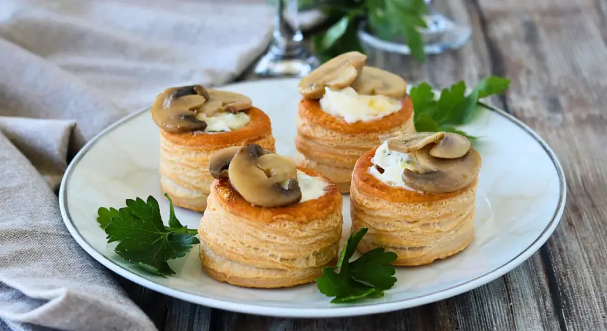 Quattro vol au vent funghi e formaggio, un antipasto sfizioso e gustoso, guarniti con prezzemolo fresco.