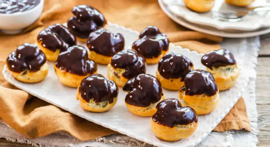 Bignè al cioccolato ricetta: deliziosi bignè ripieni e glassati al cioccolato fondente, pronti per essere gustati.