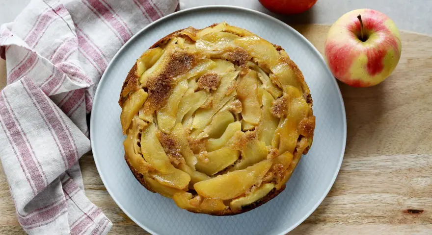 Deliziosa torta rovesciata di mele e noci, con mele caramellate disposte a spirale e una spolverata di zucchero di canna.