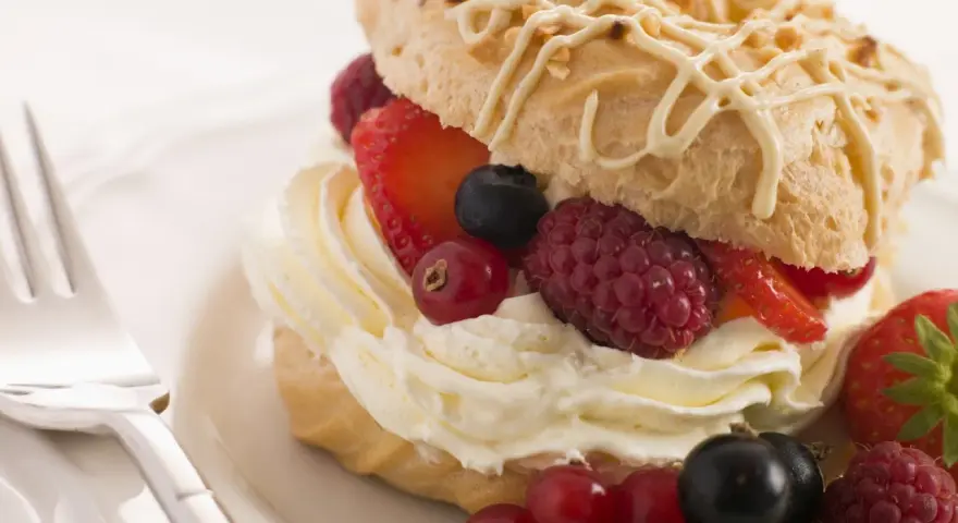Deliziosi pasticcini con crema chantilly e frutti di bosco freschi, un'esplosione di dolcezza e freschezza.