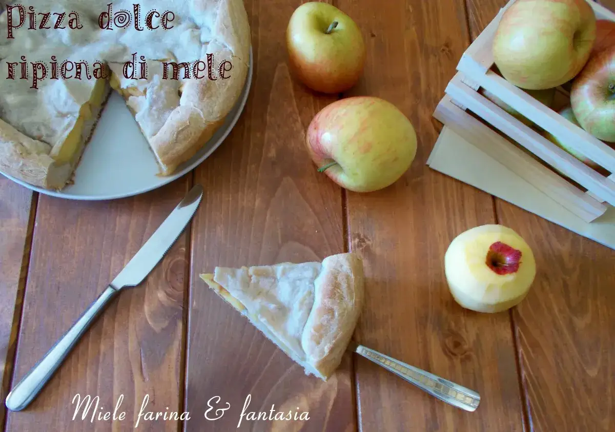 Pizza dolce ripiena di mele, con mele fresche e una fetta pronta da gustare.