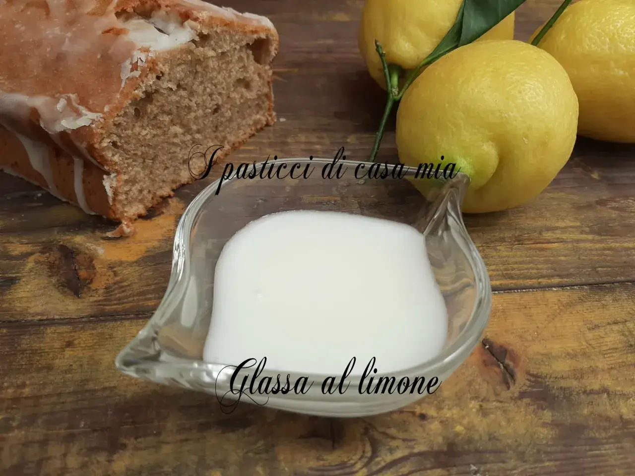Torta con glassa al limone trasparente, limoni freschi e una ciotola di glassa pronta per decorare.