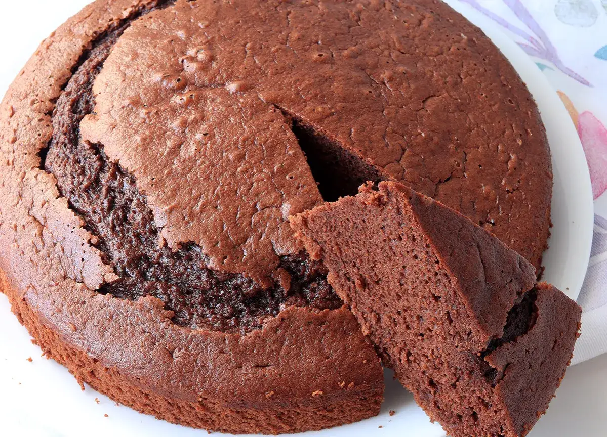 Torta al cioccolato soffice, perfetta per chi cerca un murzynek przepis facile e goloso. Una fetta invitante mostra la sua morbidezza.