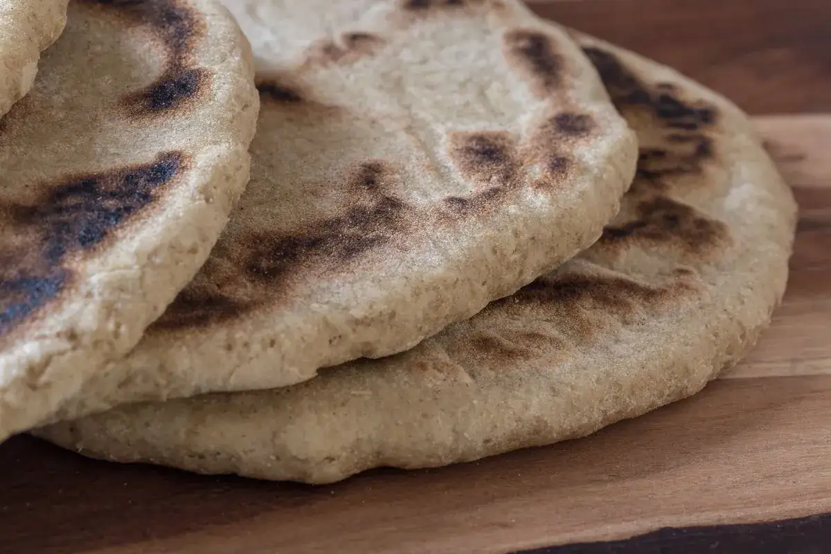 Pane azzimo integrale ricetta: focaccine dorate con macchie scure, pronte per essere gustate.
