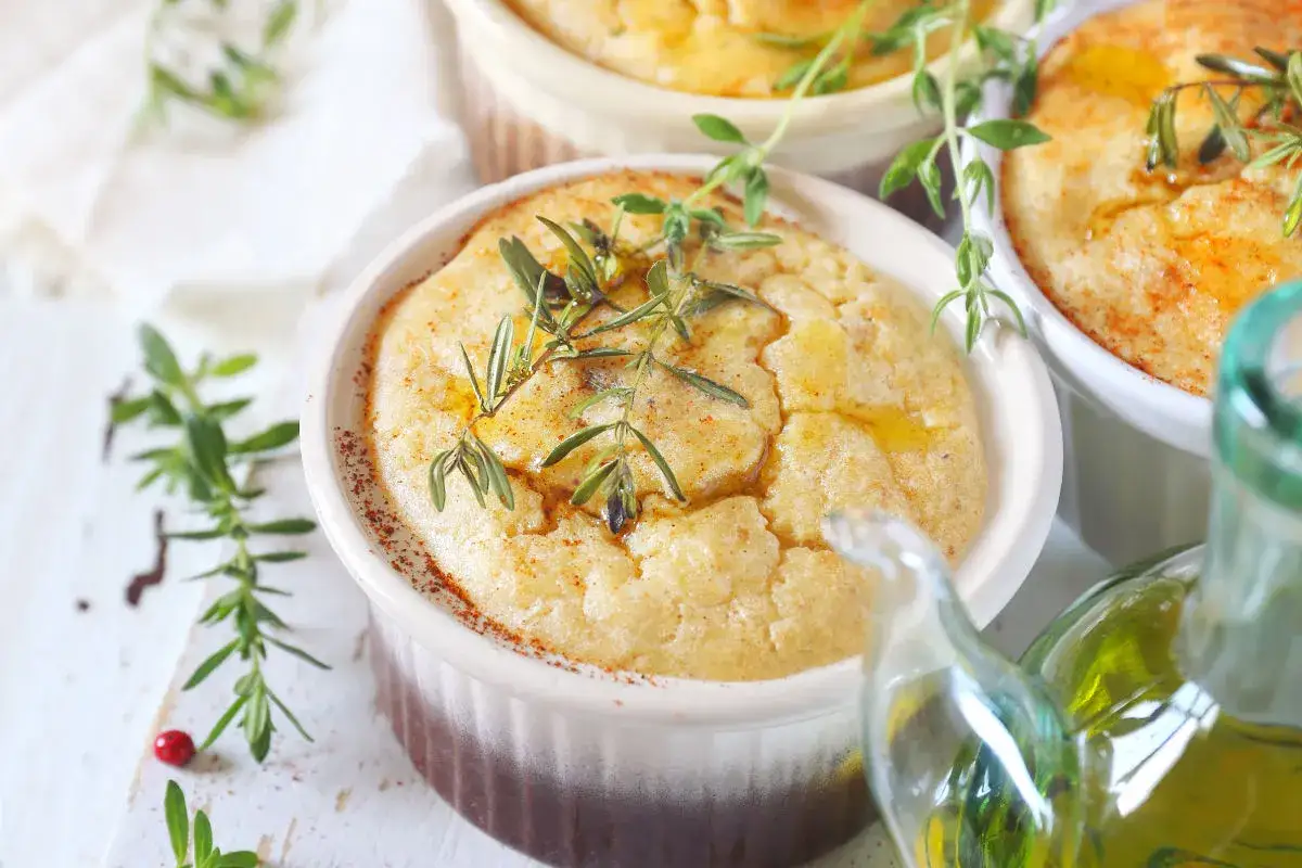 Delizioso flan di topinambur senza patate, guarnito con erbe aromatiche fresche e un filo d'olio d'oliva.