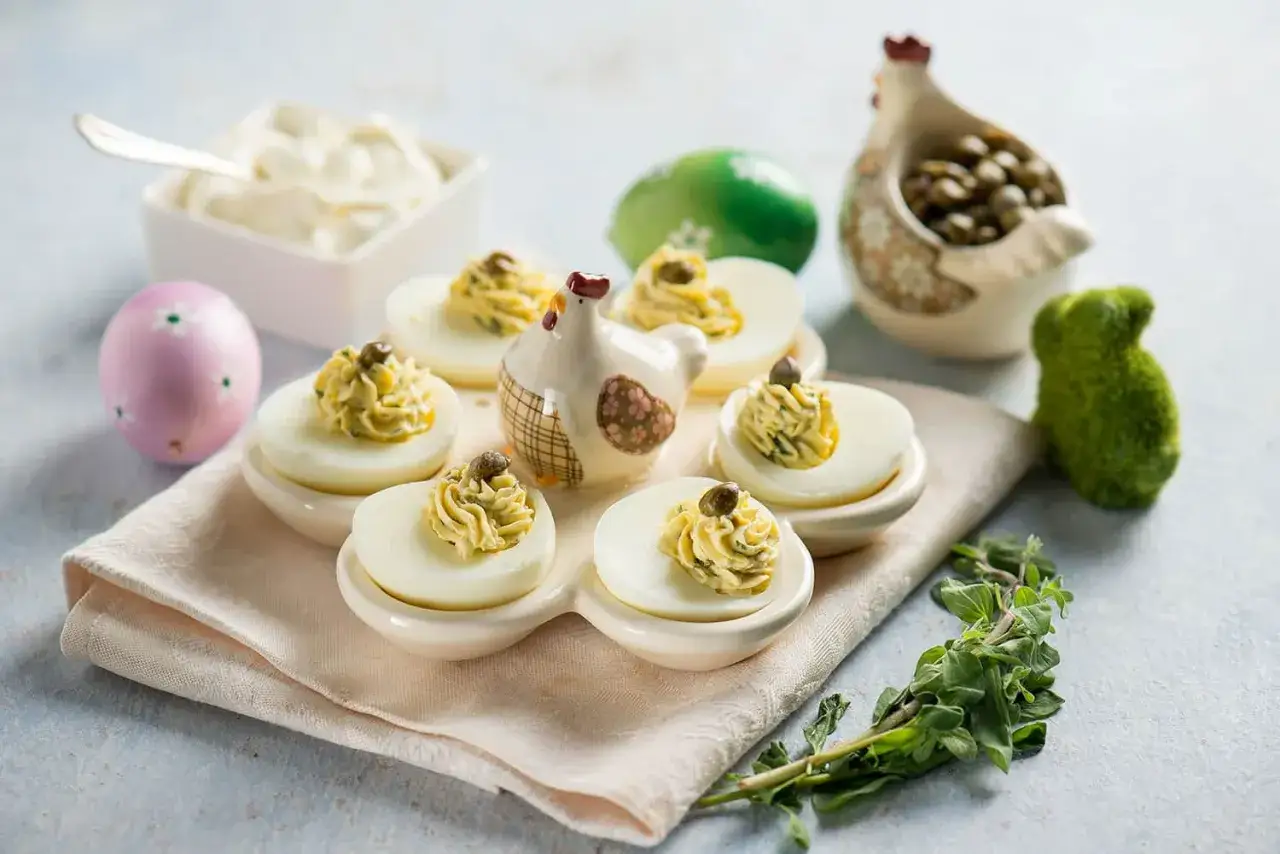 Deliziosi jajka faszerowane, guarniti con capperi, su un tovagliolo con decorazioni pasquali.