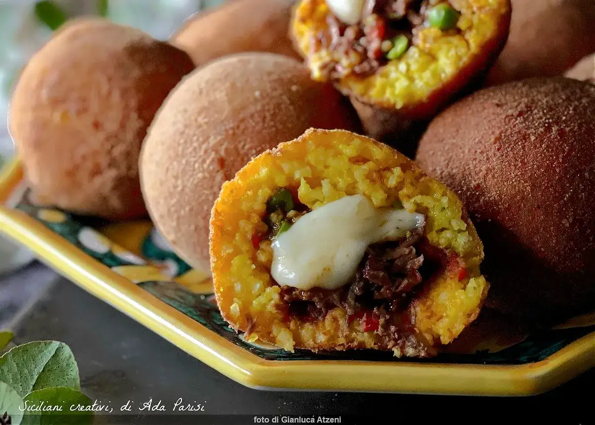 Arancini ripieni di carne e formaggio filante, un delizioso arancini ricetta siciliana.