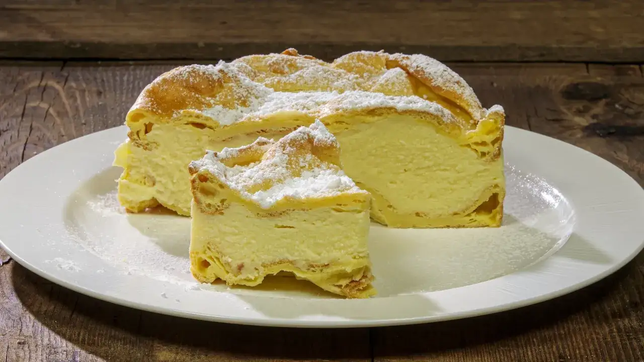 Fetta di Karpatka, dolce polacco con crema pasticcera e pasta choux, spolverata di zucchero a velo. Un delizioso karpatka przepis.
