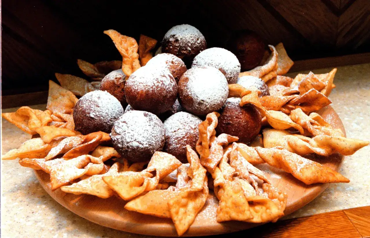 Piatto di dolci fritti, palline cosparse di zucchero a velo e chiacchiere croccanti, perfetti per il 