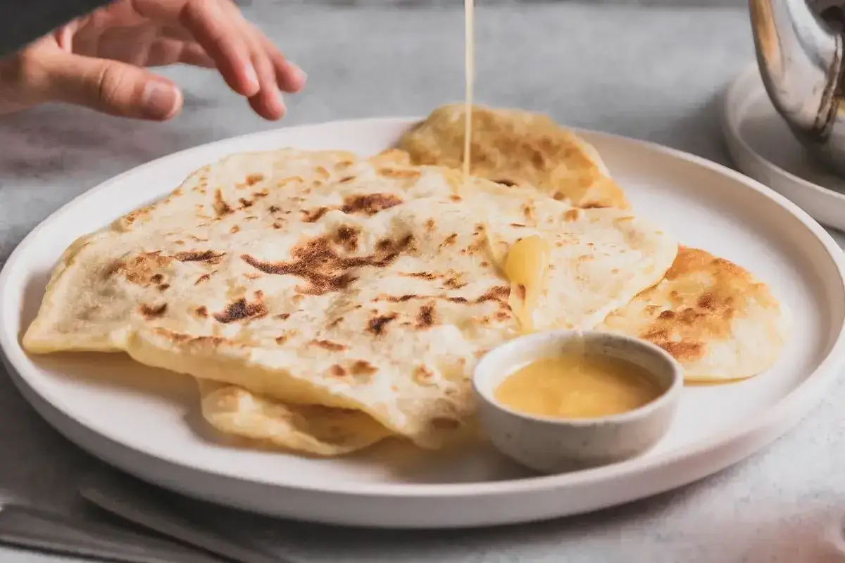 Msemmen marocchino, sfogliato e dorato, pronto per essere inzuppato nel miele. Una delizia per la colazione, seguendo la ricetta tradizionale.