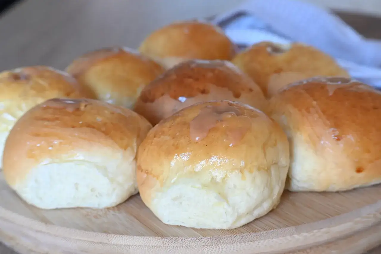 Bomboloni dorati e soffici, alcuni con una glassa che ricorda le caramelle, pronti per essere gustati.