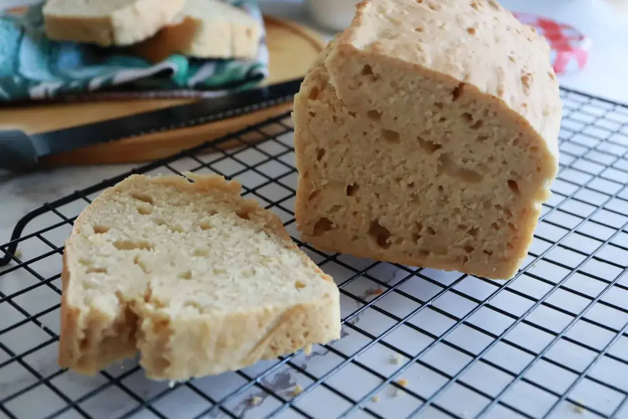 Fetta di pane soffice e dorato, preparato con cremor tartaro, su una griglia di raffreddamento.