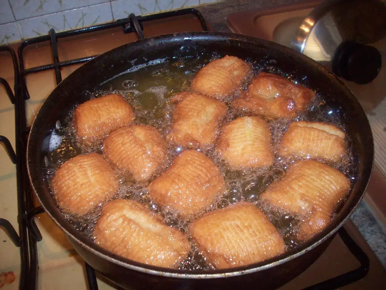 Turdiddri calabresi dorati friggono in olio bollente, creando un profumo invitante.