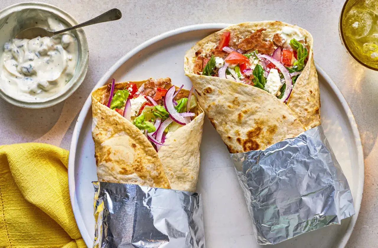 Due succulenti tortilla kebab, ripieni di carne, verdure fresche e formaggio feta, pronti per essere gustati.