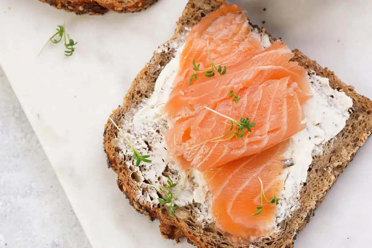 Bruschette con salmone affumicato, formaggio cremoso e germogli freschi su pane integrale. Un'esplosione di gusto e freschezza.