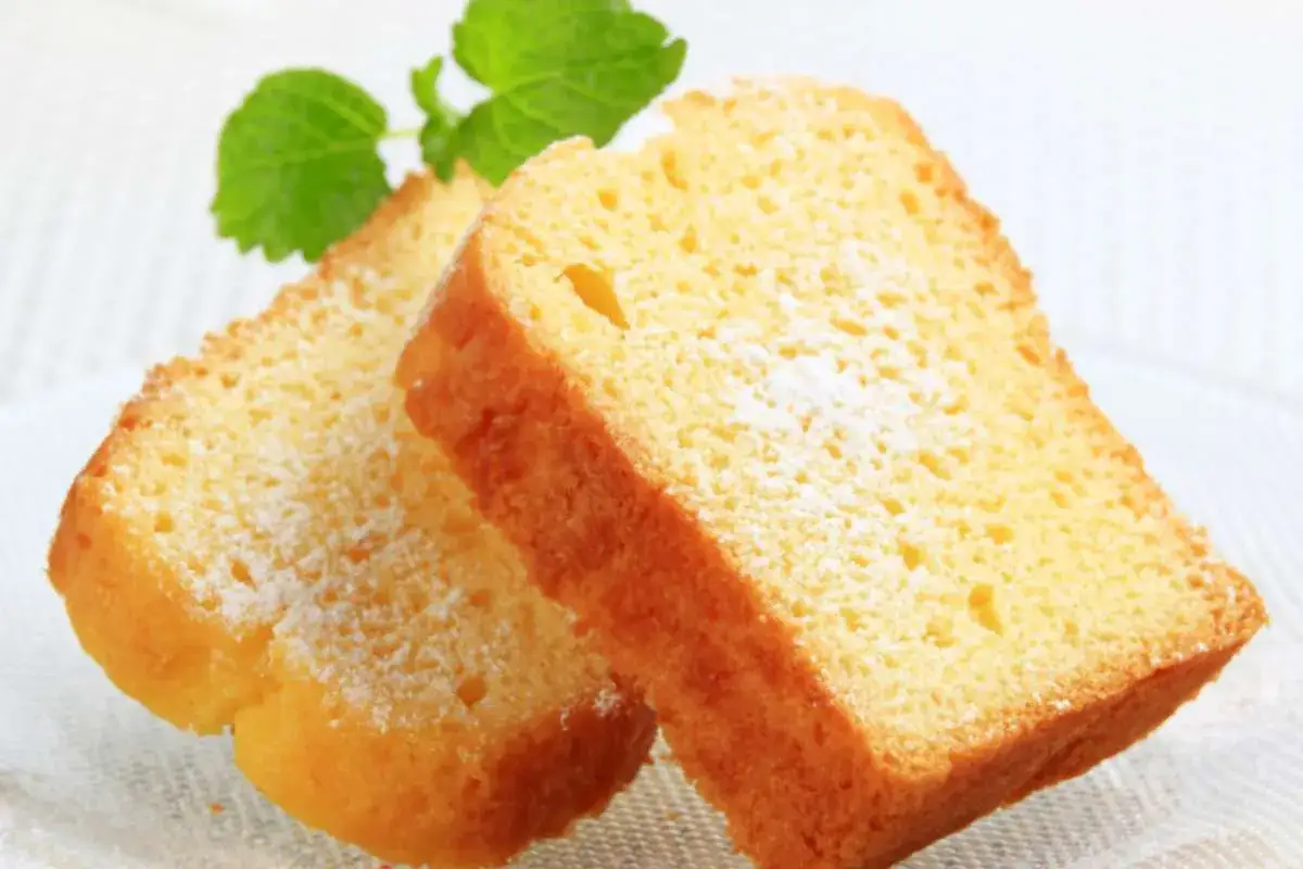 Fette di plumcake ricotta e mele spolverate di zucchero a velo, con una fogliolina verde in cima.