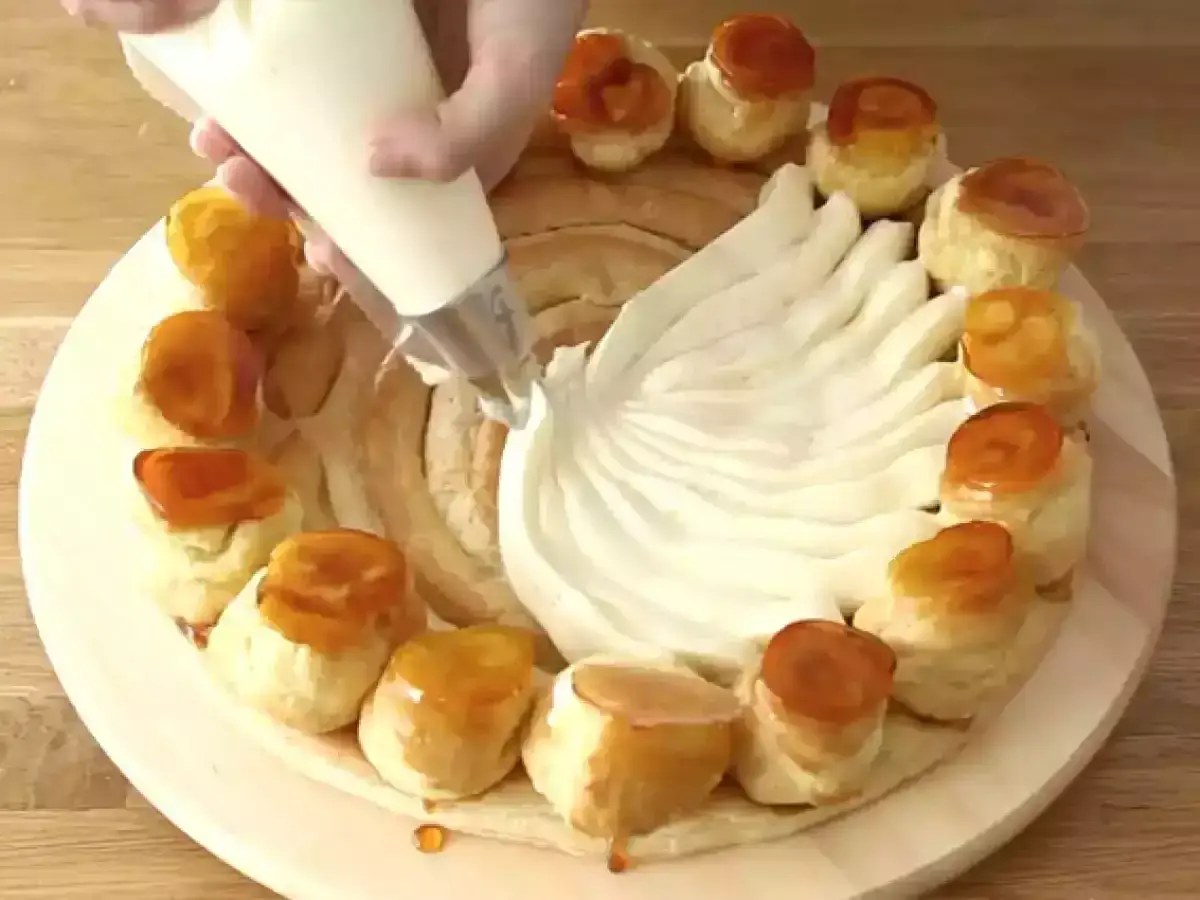 Decorazione di una torta con crema chiboust ricetta originale, con sac à poche che crea un motivo a ventaglio.