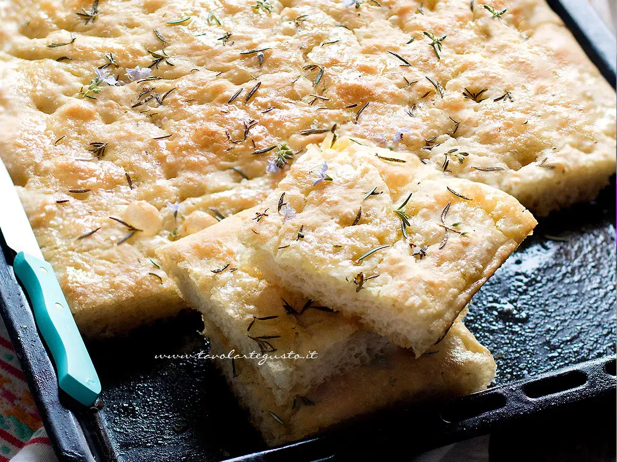 Focaccia fragrante con rosmarino e fiorellini, pronta per essere gustata. Un ottimo focaccia przepis per ogni occasione.
