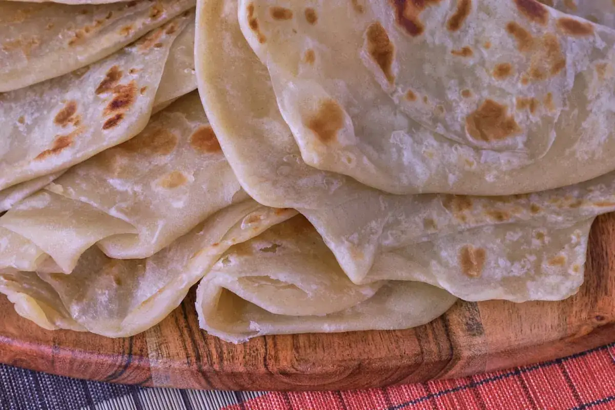 Pila di piadine africane, sottili e dorate, pronte per essere gustate.
