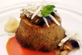 Sformato di melanzane leggero, guarnito con scaglie di formaggio, basilico e servito con salsa rossa e purè.